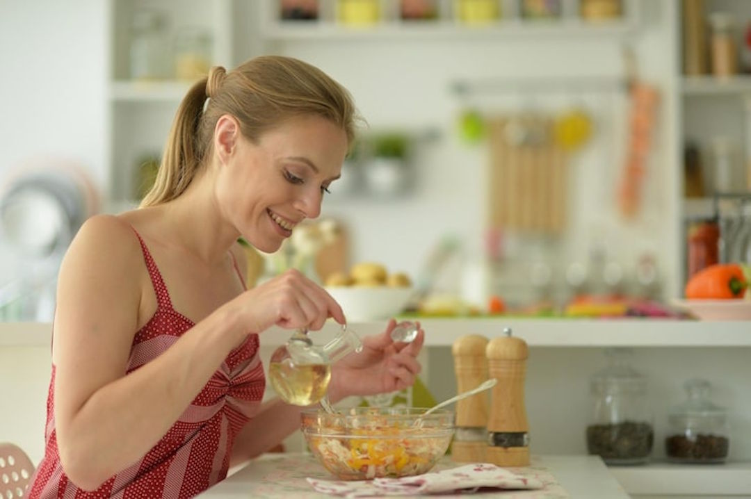 Une femme qui utilise l'huile d'arachide en cuisine