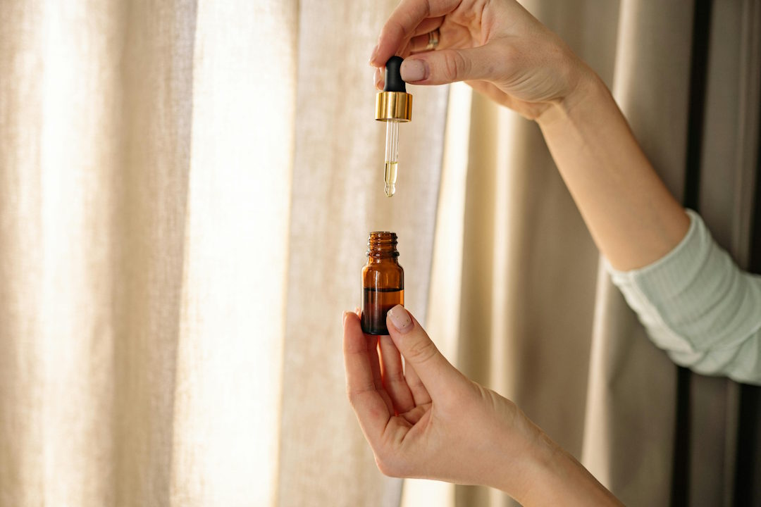 Une personne qui prend quelques gouttes d'huile essentielle