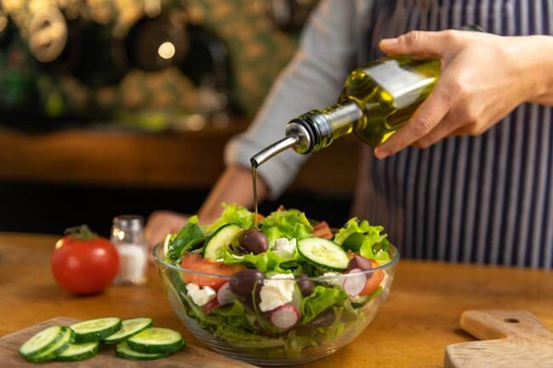 Une bol de salade mélangée avec de l'huile 