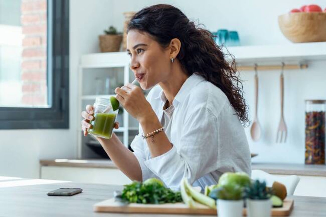 Une femme qui boit un verre d'Ashwagandha