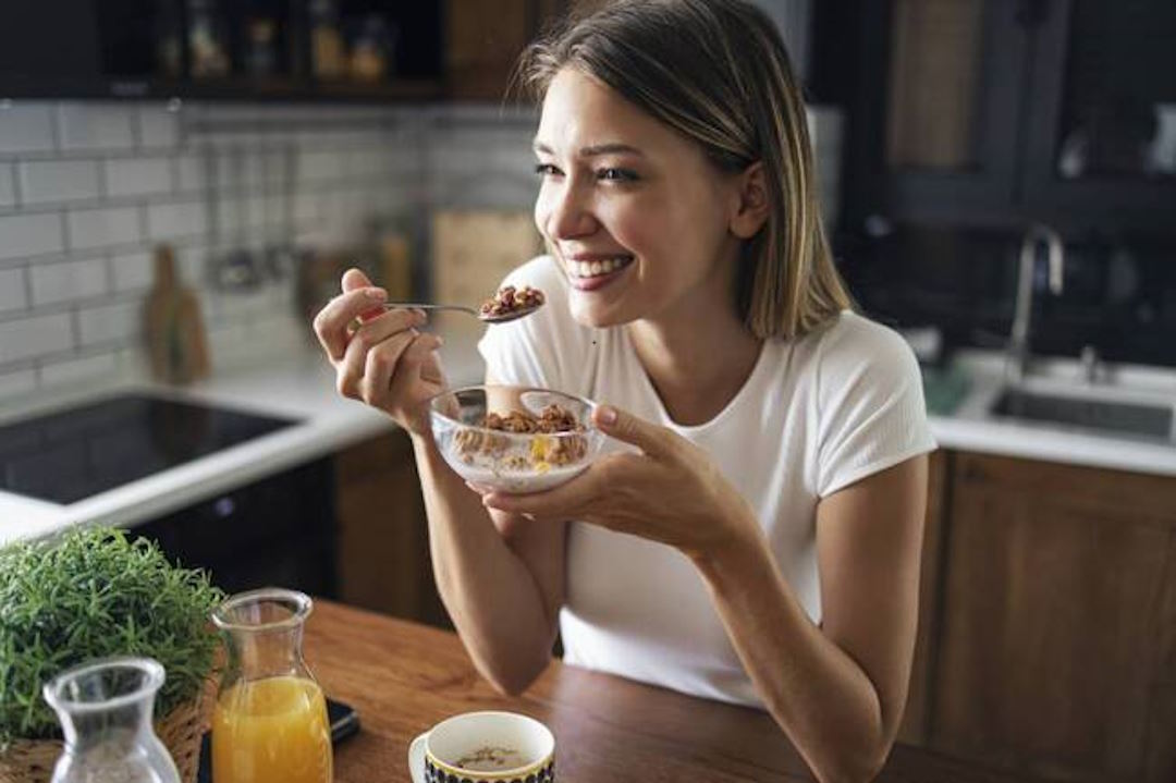 Une femme qui mange un plat riche en magnésium