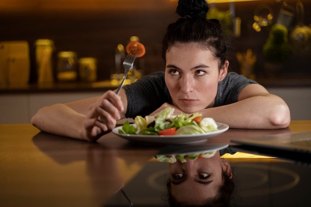 Une femme qui regarde son plat du soir