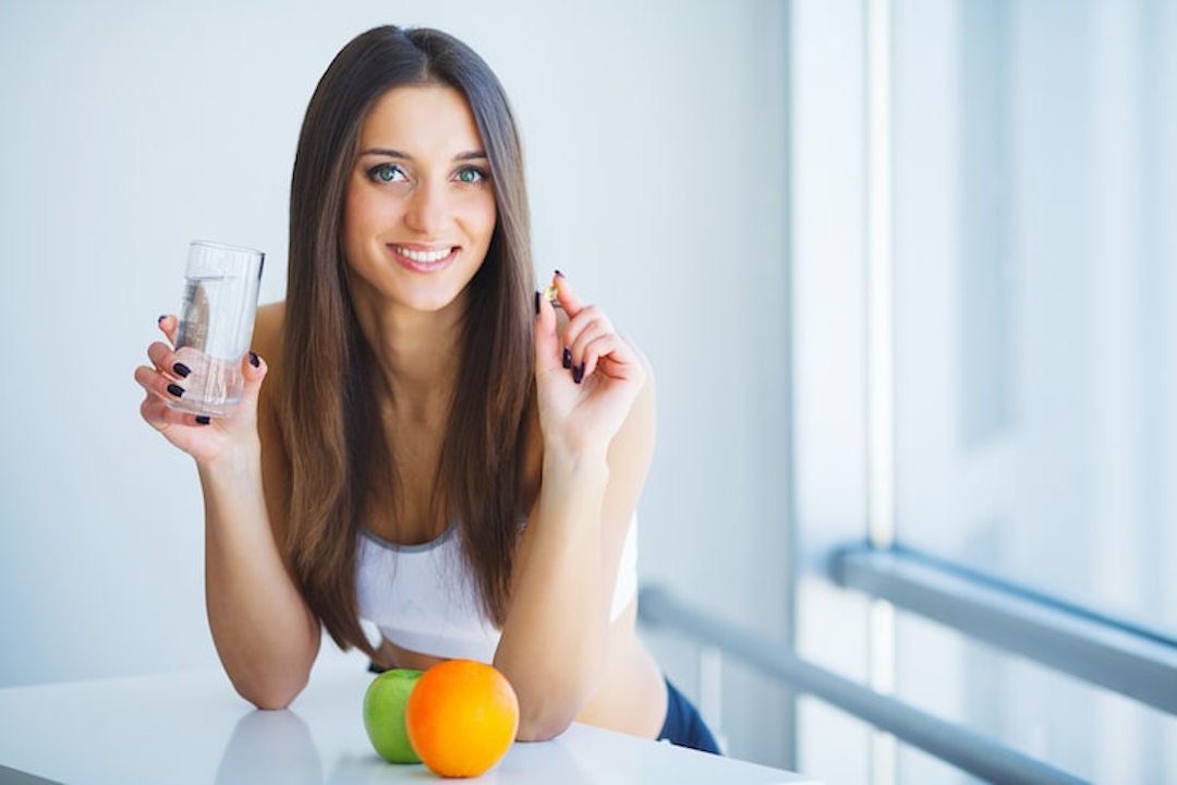 Une femme qui prend des mlultivitamines