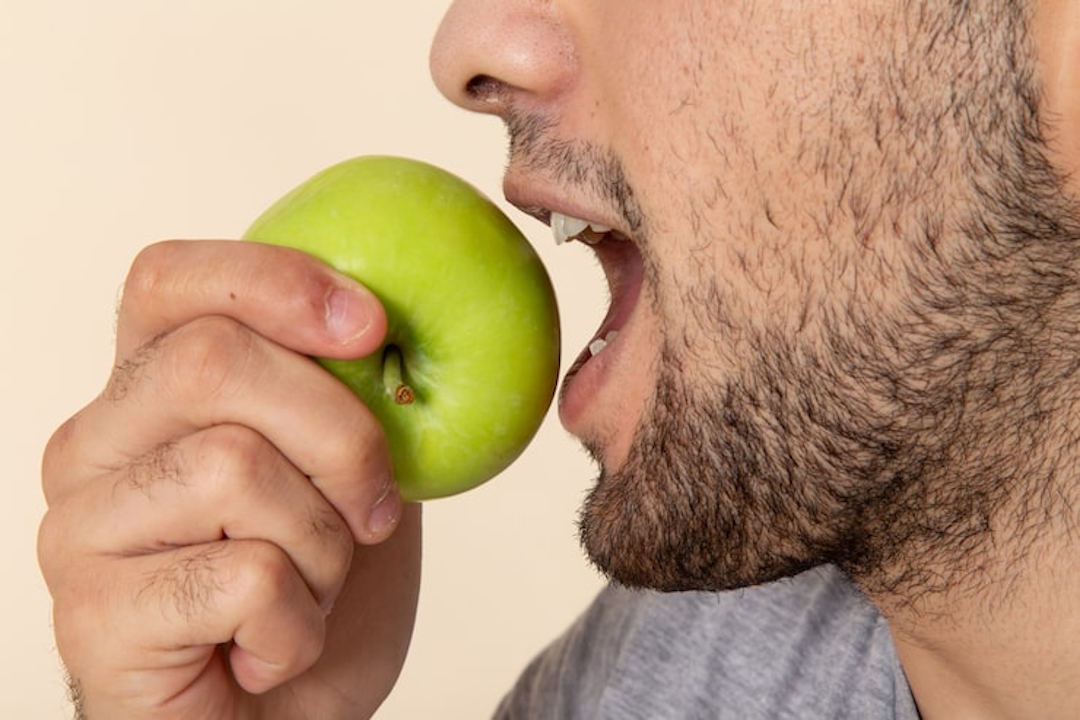 Un homme qui mange une pomme pour couper la faim
