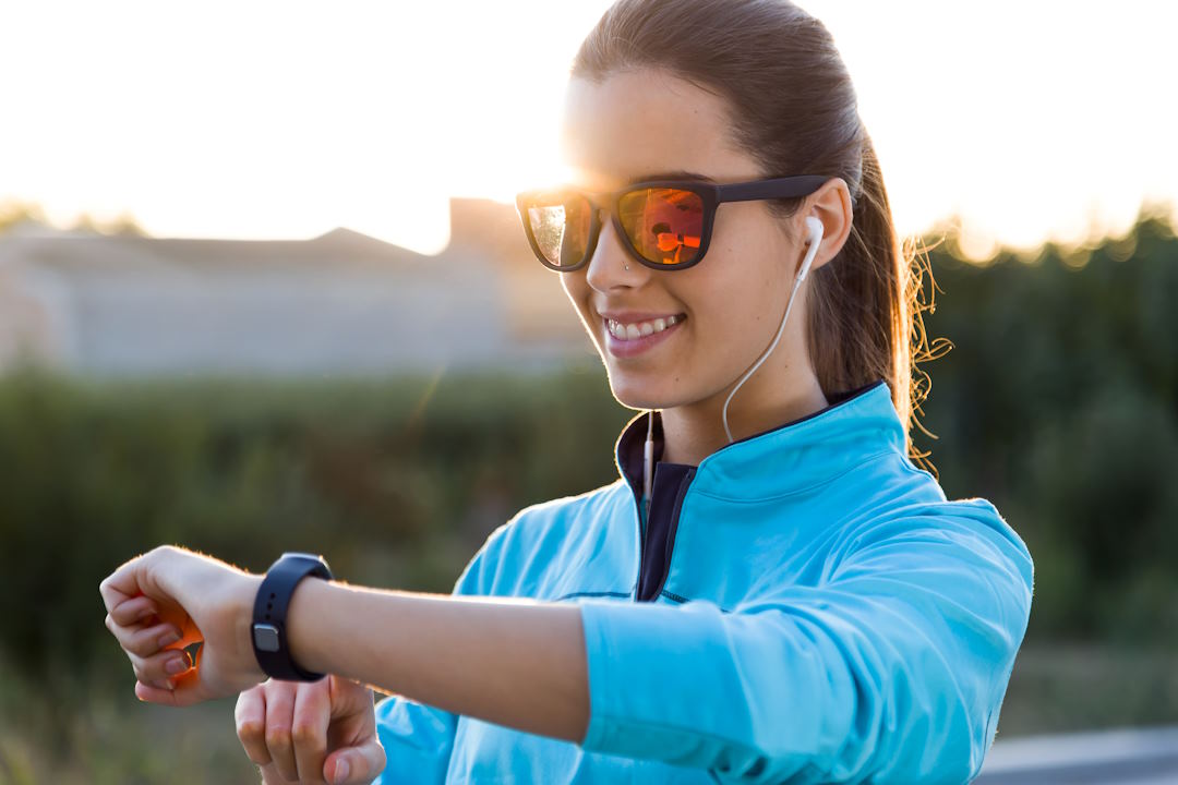 Une femme qui regarde sa montre pour faire de la course à pied