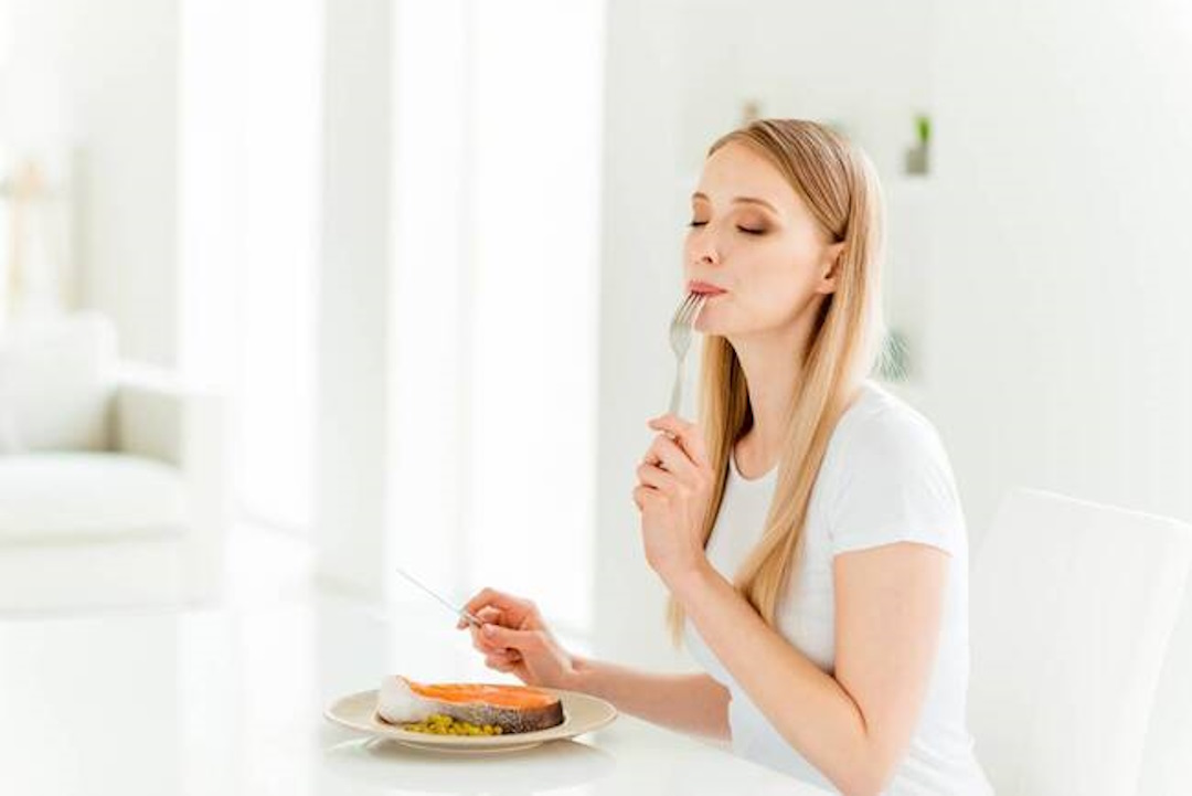 une femme qui mange du poisson , riche en oméga 3