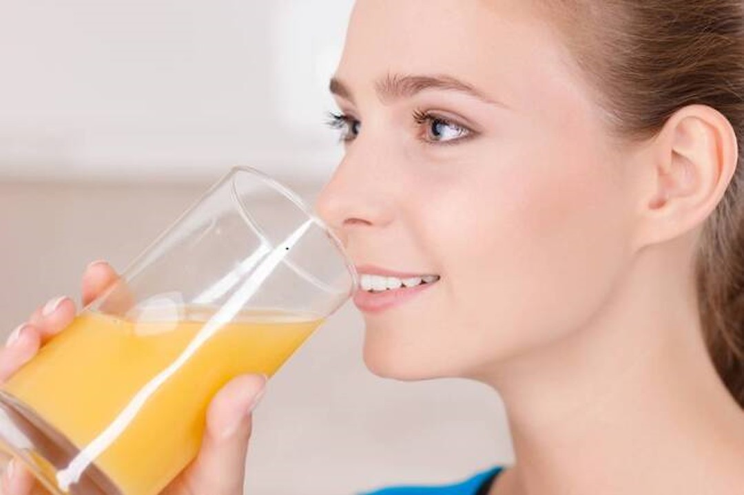 Une femme qui boit son jus de fruits