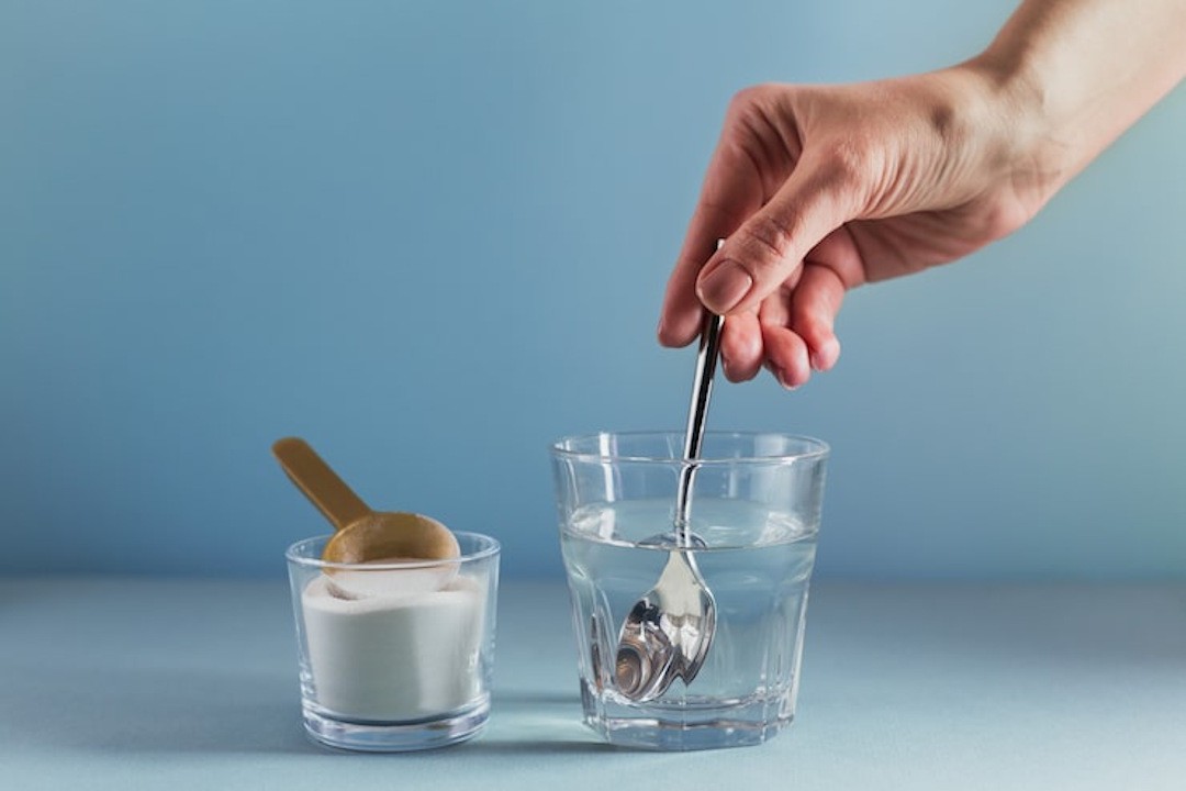 Une personne qui m&eacute;lange de l'eau et de la bicarbonate de soude pour am&eacute;liorer la digestion