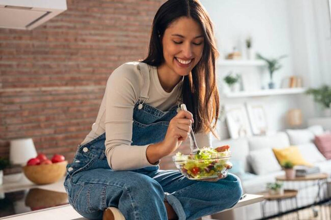 Une femme qui mange une salade pour la vitamine D