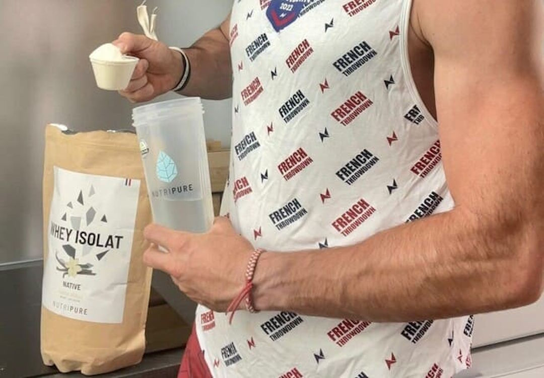 Un homme qui prépare un shaker de Whey isolat