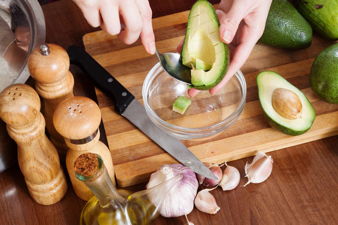Une personne qui prépare de l'avocat pour un bon apport en vitamine B3