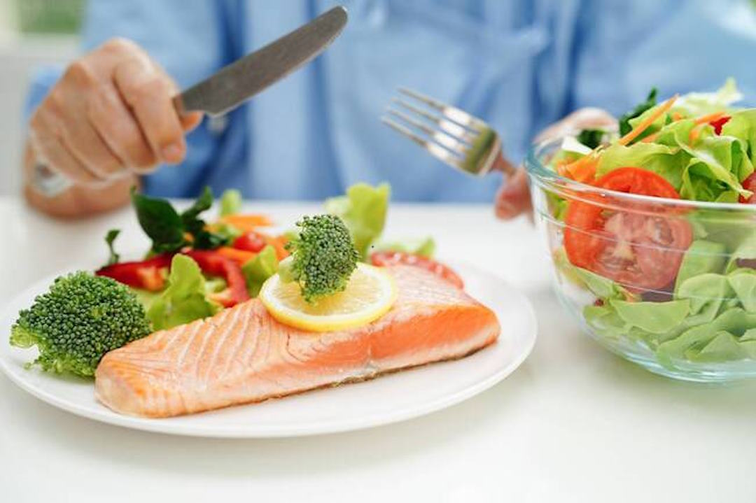 Un salade de légume avec une tranche de poisson