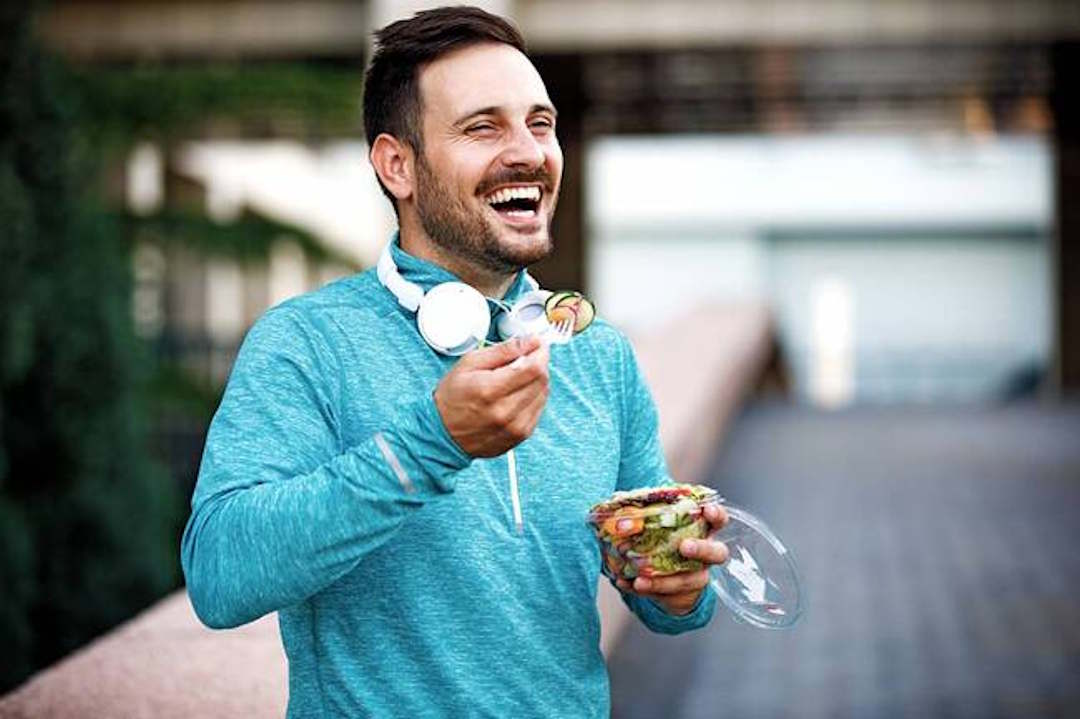 Un homme qui mange son petit déjeuner riche en vitamine C
