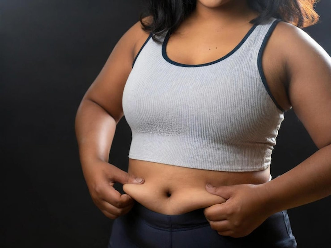 Une femme qui vérifie la graisse abdominale