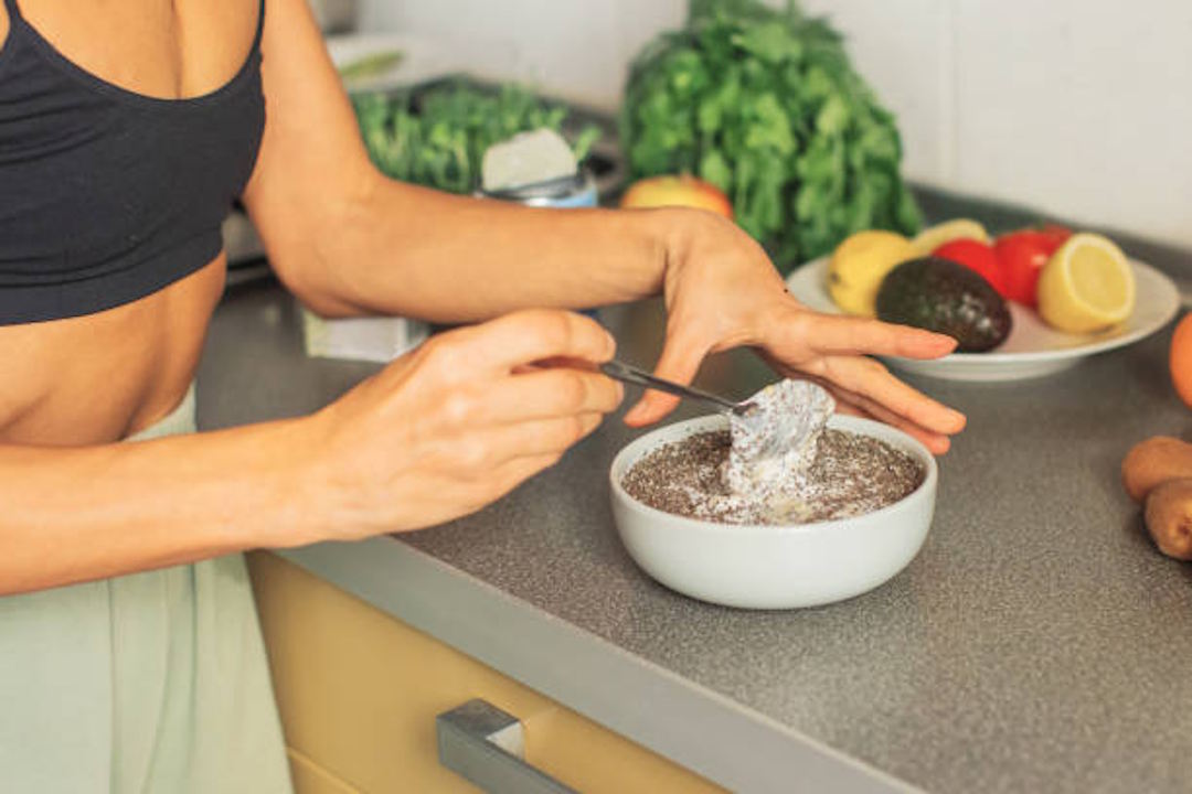 Une personne qui prépare une assiette de graines de chia pour la fonction musculaire