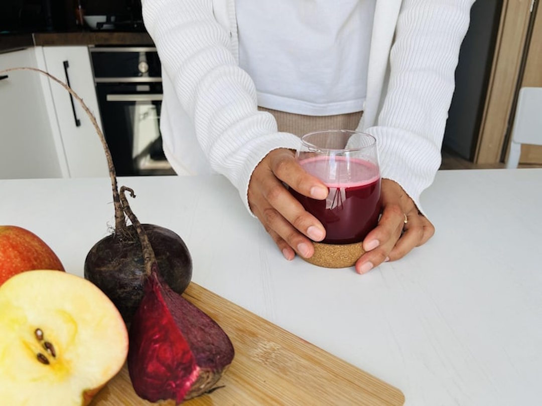 Une femme qui boit du jus de betterave
