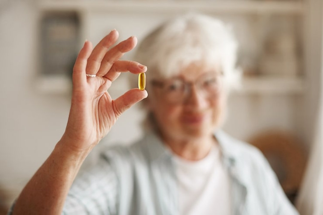 Une femme âgée qui prend de la vitamine D