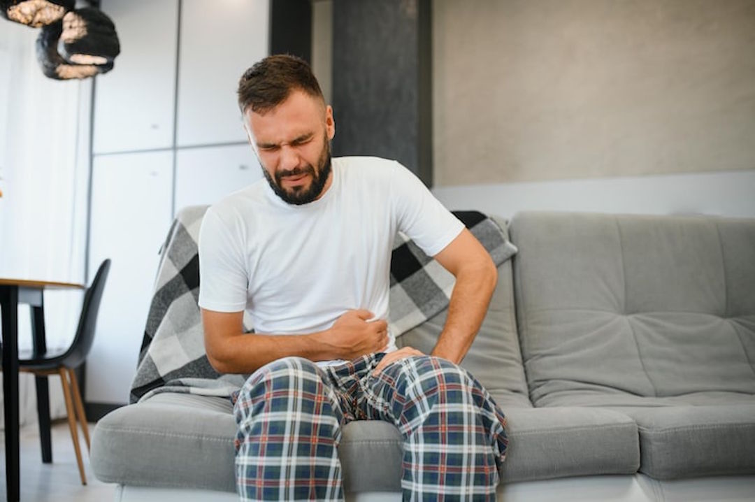 Un homme qui souffre de douleur au ventre à cause d'un surdosage de magnésium