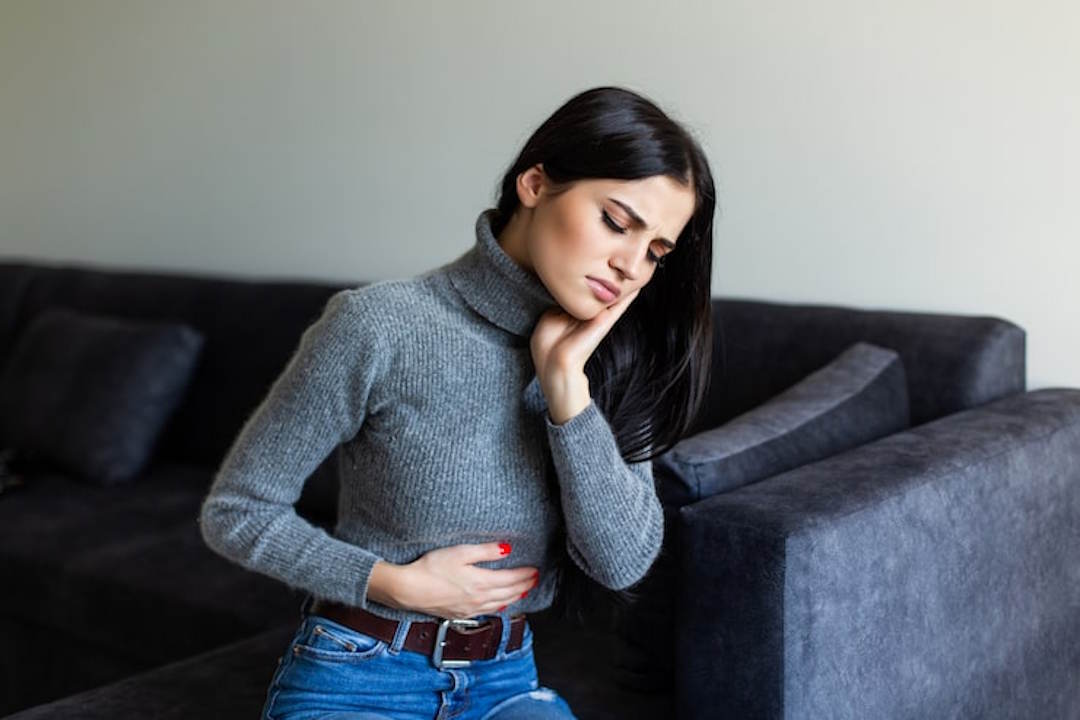 Une femme qui se tient le ventre de douleurs