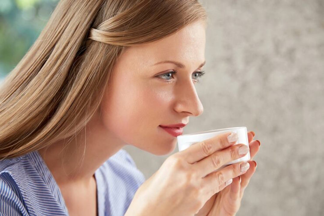 Un femme qui boit une tasse de thé aliment bon pour le foie