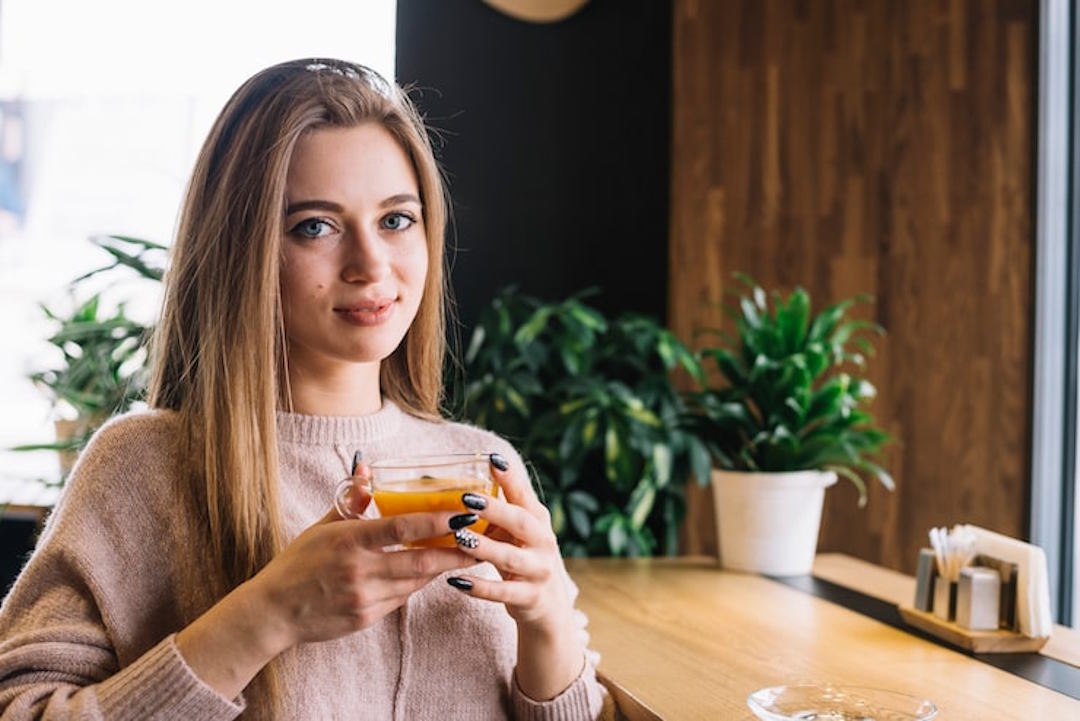 Une femme qui boitune tisane de cumin
