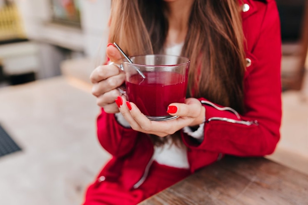 Une femme qui boit de la tisane d'hibiscus pour la digestion