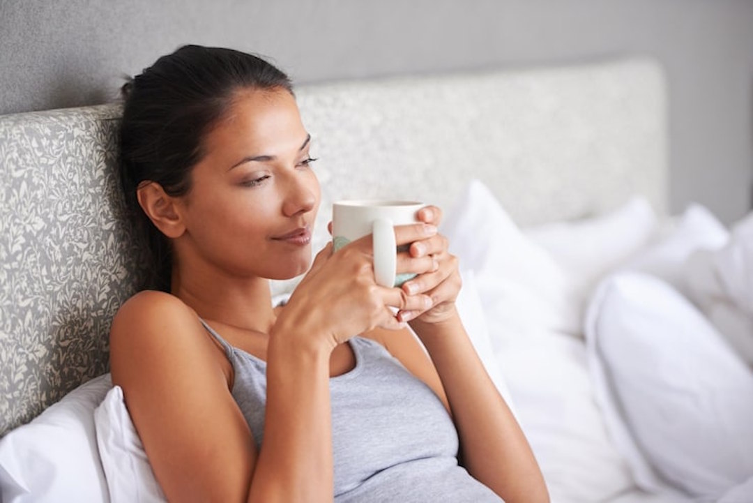 Une femme qui boit une tisane avant d'aller dormir après des somnifères sans ordonance