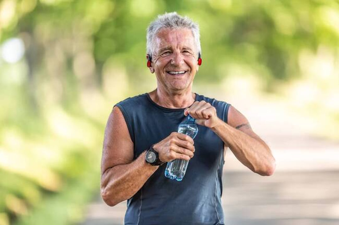 Un homme plus âgé qui s'hydrate avec de l'eau