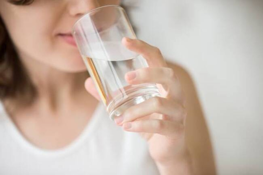 Une femme qui boit de l'eau riche en magnésium