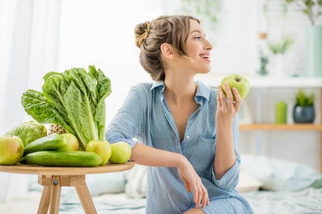 Une femme qui tient une pomme dans sa main
