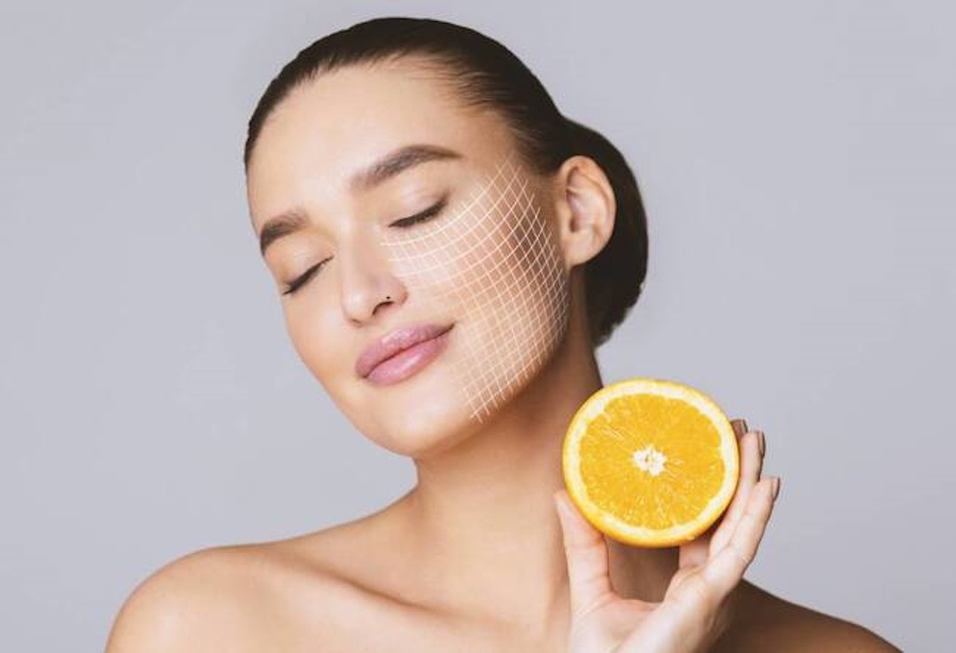 Une femme qui tient dans sa main un demi orange