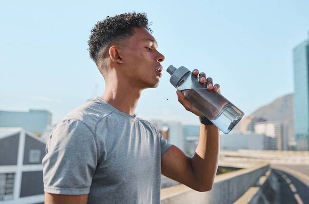 Un homme qui s'hydrate en plein chaleur