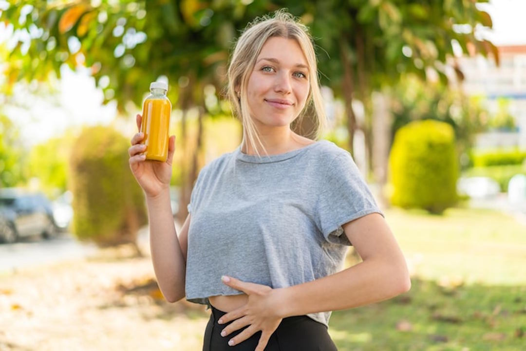 Une femme qui tient un jus dans sa main