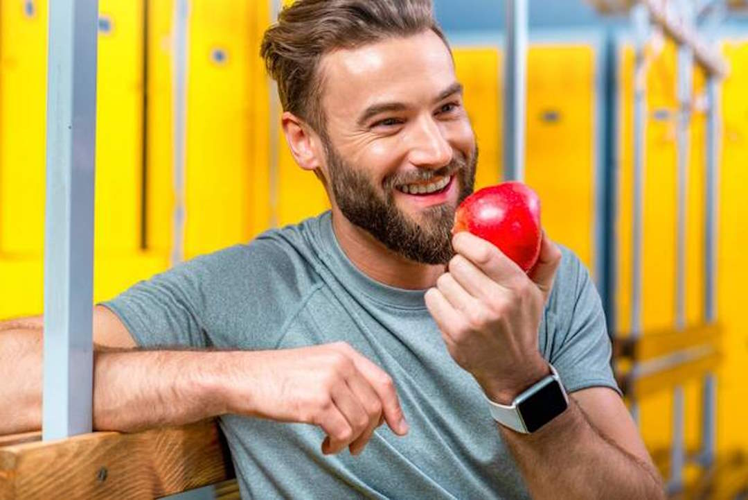 Un homme qui tient une pomme dans la main