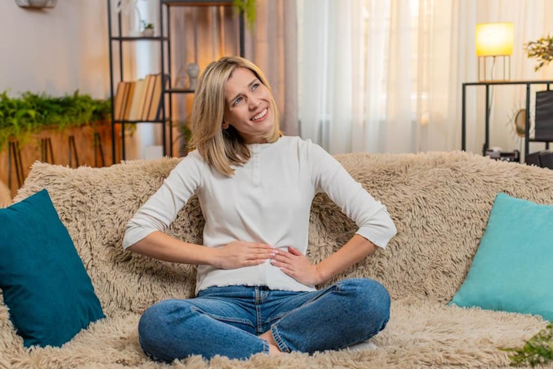 Une femme souriante avec un bien-être digestif grâce aux bienfaits de la sauge