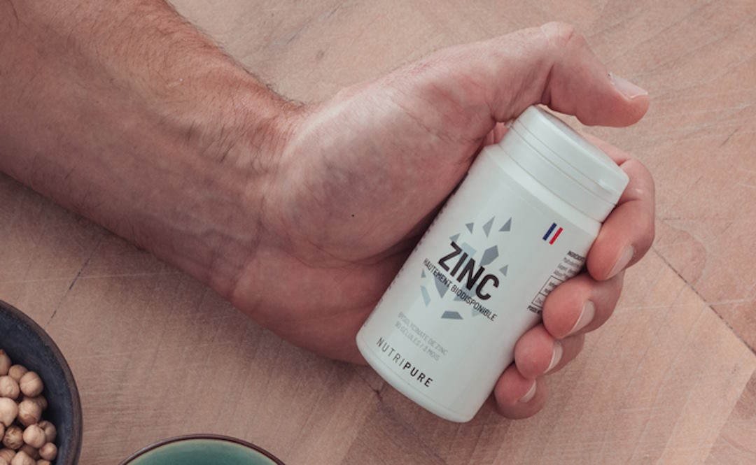 La main d'un homme qui tient un flacon de zinc